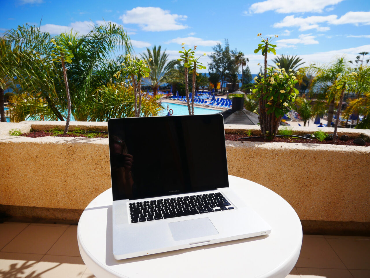 laptop on vacation next to hotel pool