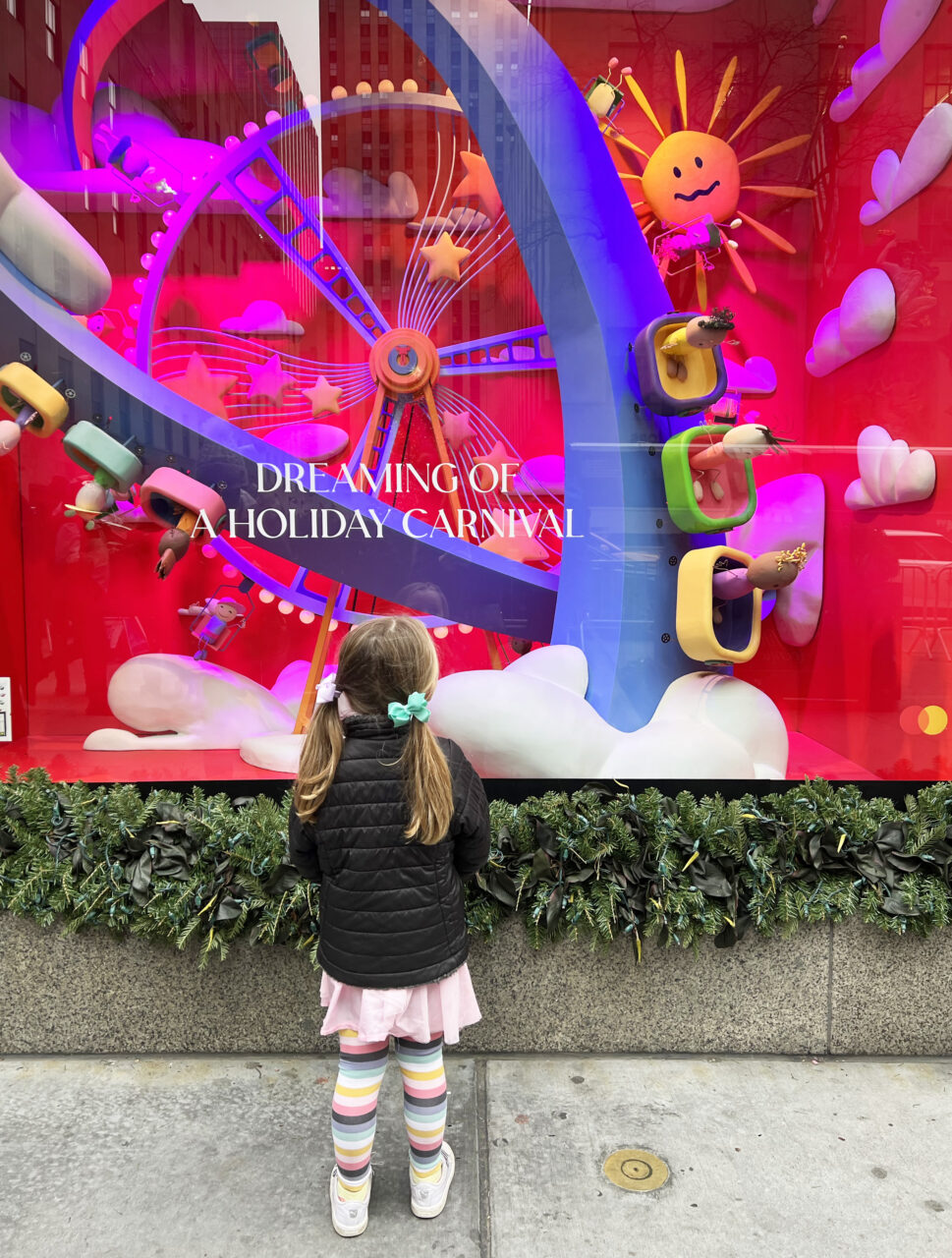 Girl looking at a holiday window display at Saks Fifth Avenue
