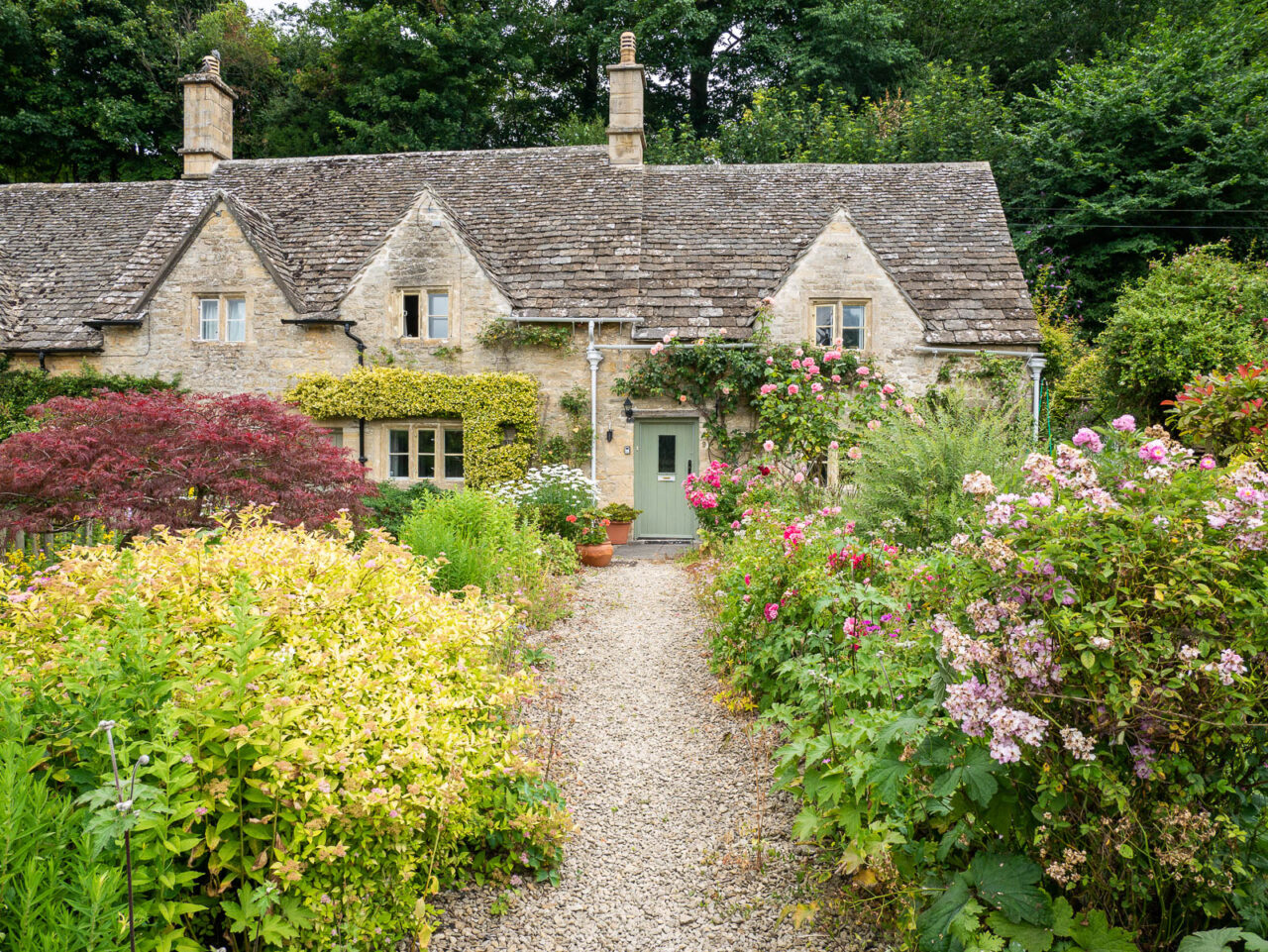 Pretty cottage covered in flowers in the Cotswolds England