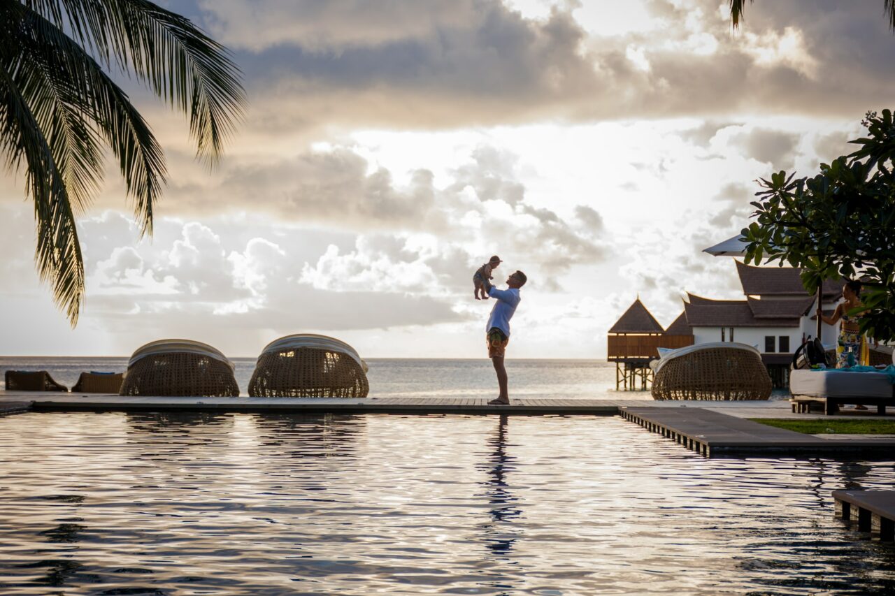 Man holding baby on vacation at a resort