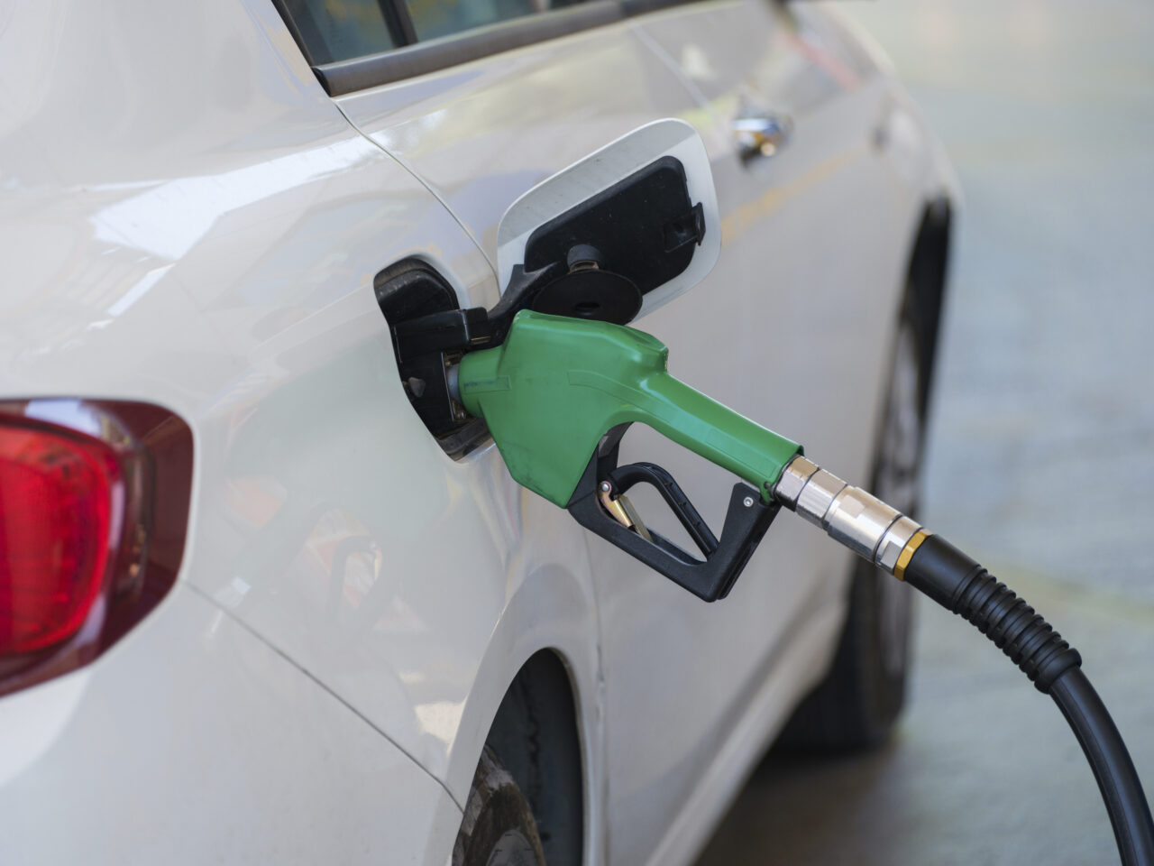 Gas pump nozzle fueling up a car