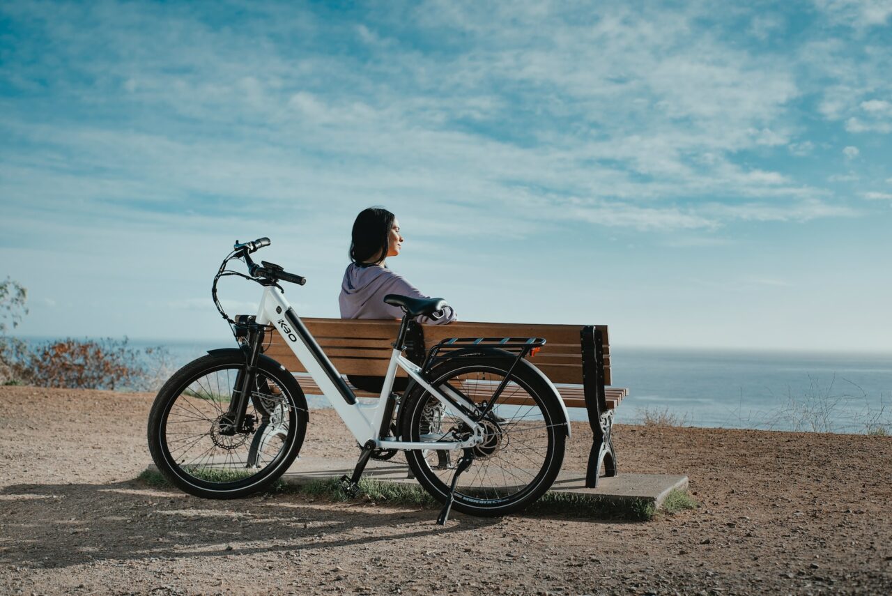 Woman on a bench with an electric bike