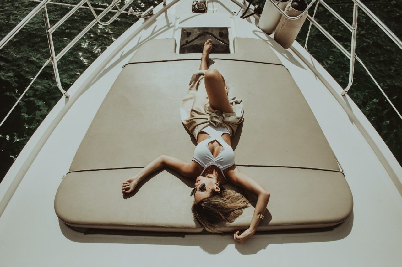 Woman sunbathing on a yacht in a onepiece swimsuit