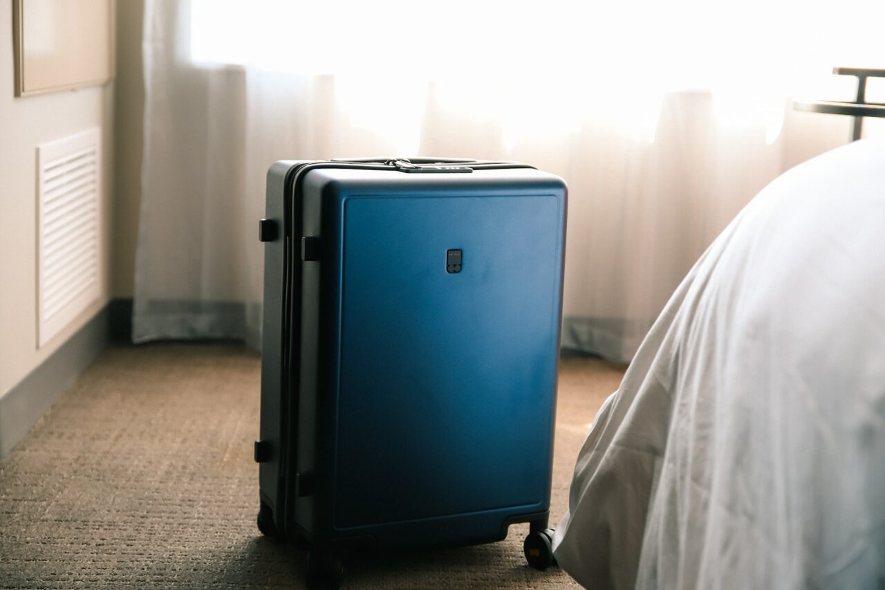 Suitcase next to a bed
