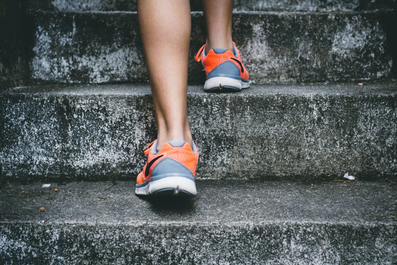 Person wearing running shoes climbing up steps