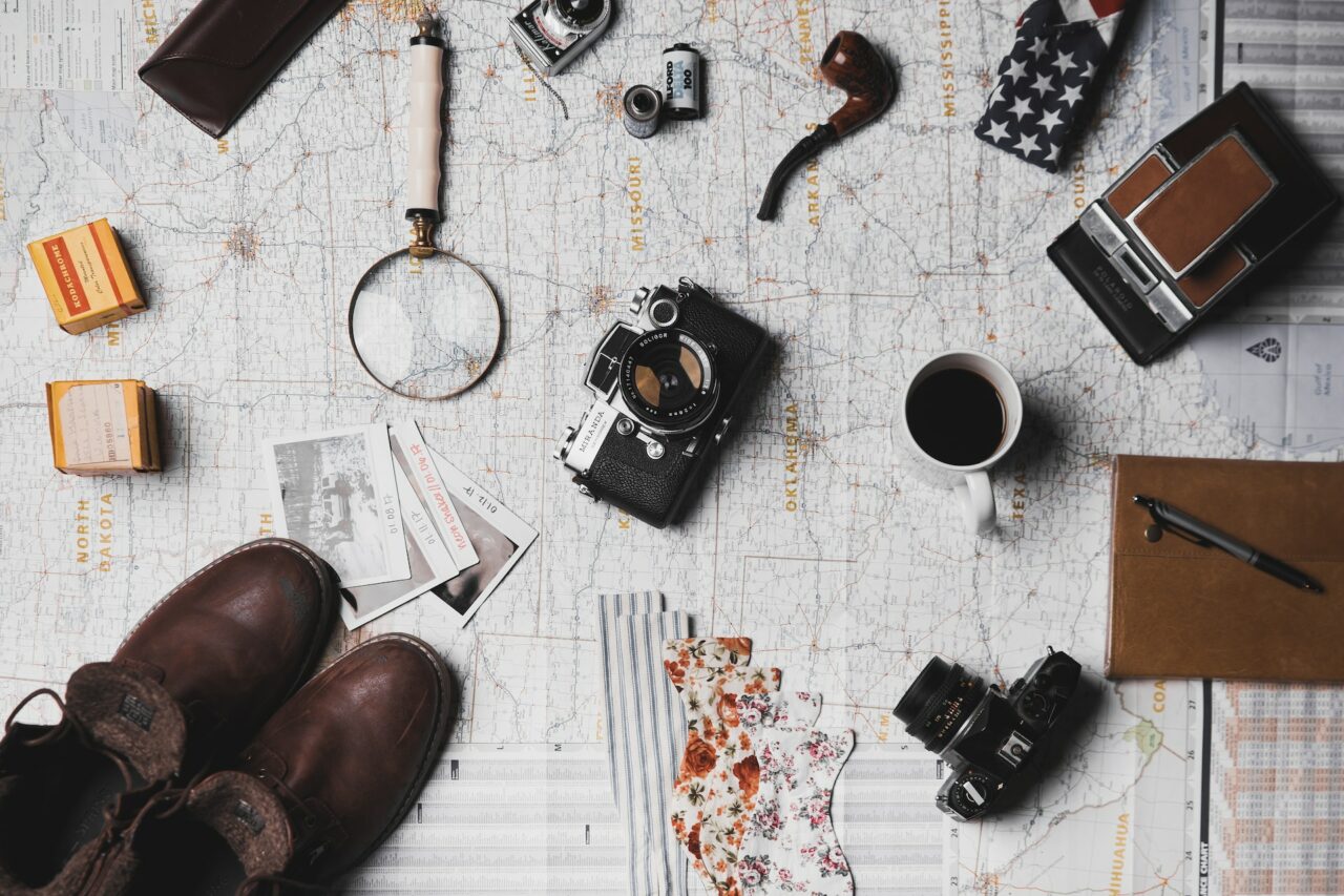 Camera, shoes and mug on top of a map