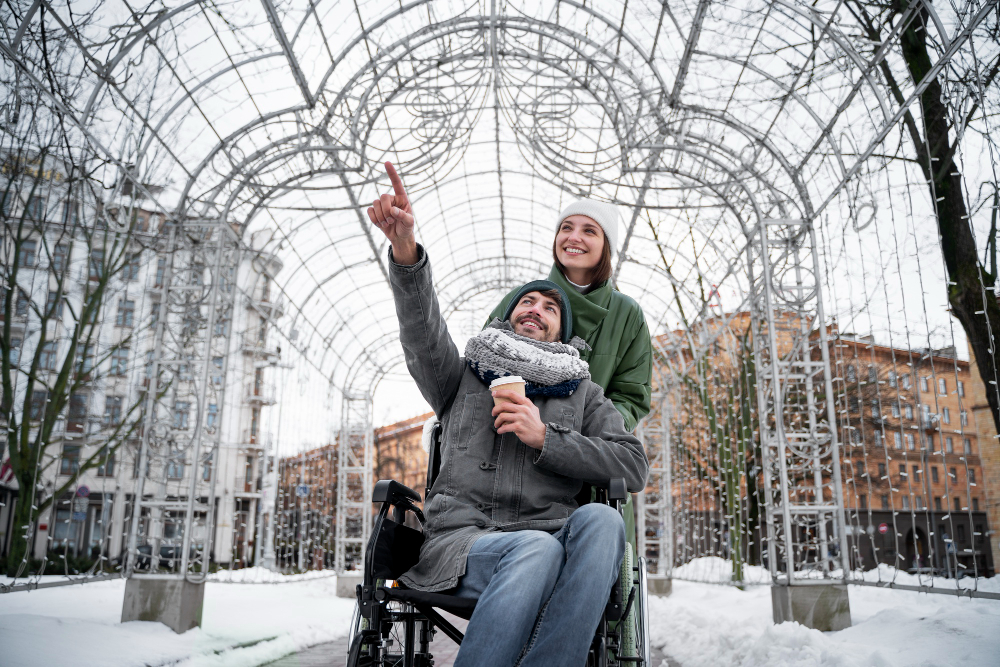 Woman pushing a man in a wheelchair in winter