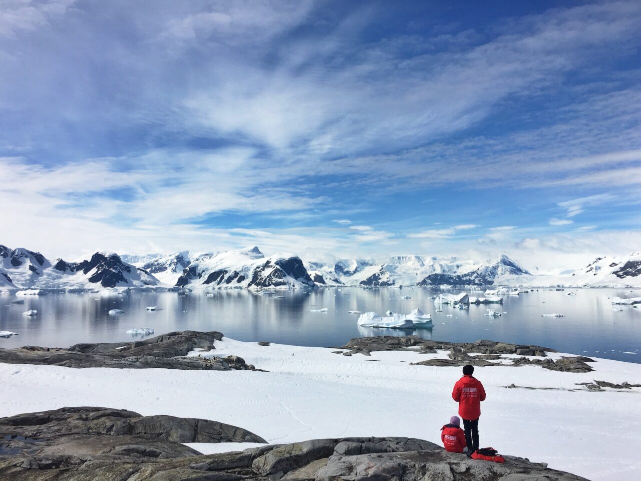 Couple standing on a rock in Antarctica