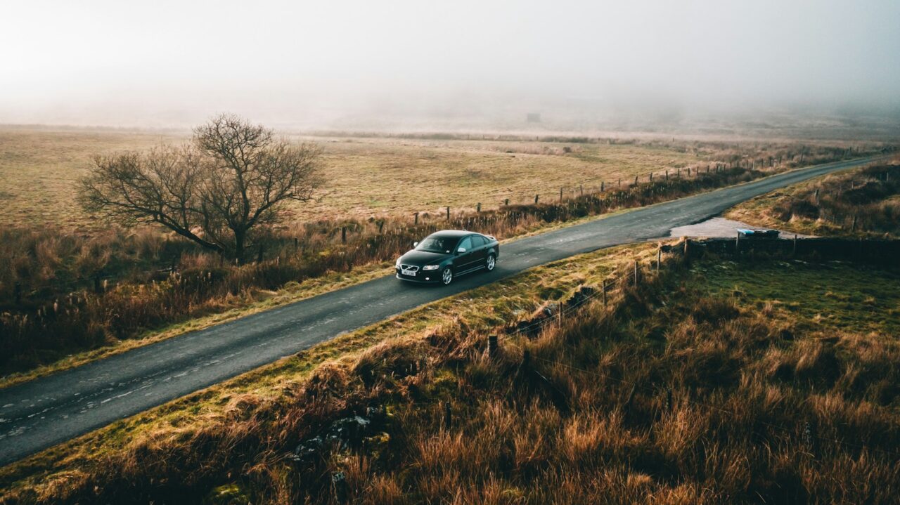 Car driving along an empty road in The Roaches, Leek, UK