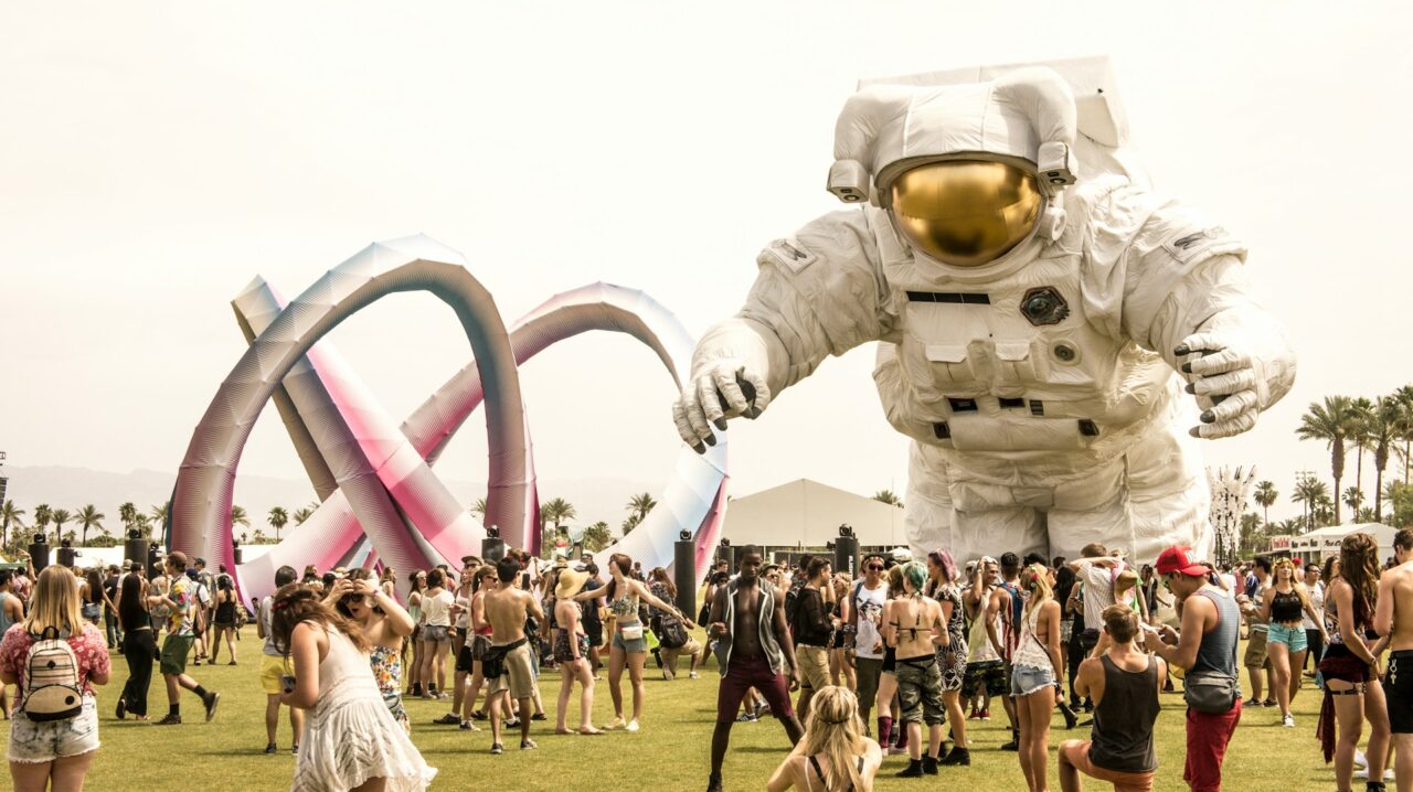 Astronaut sculpture and a crowd full of people at Coachella