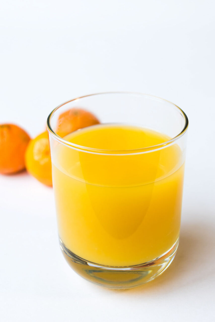 Glass of orange juice on a white background