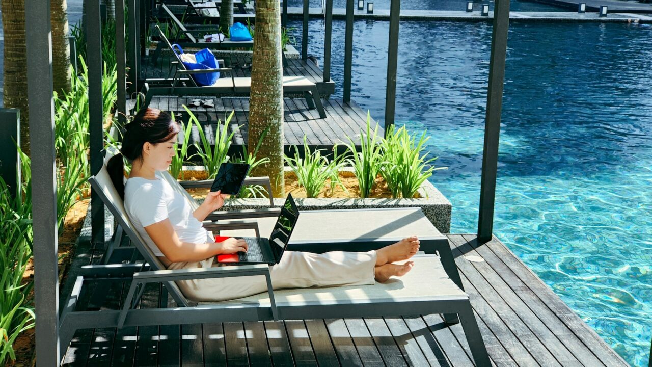 Woman sitting on a sun lounger using a laptop
