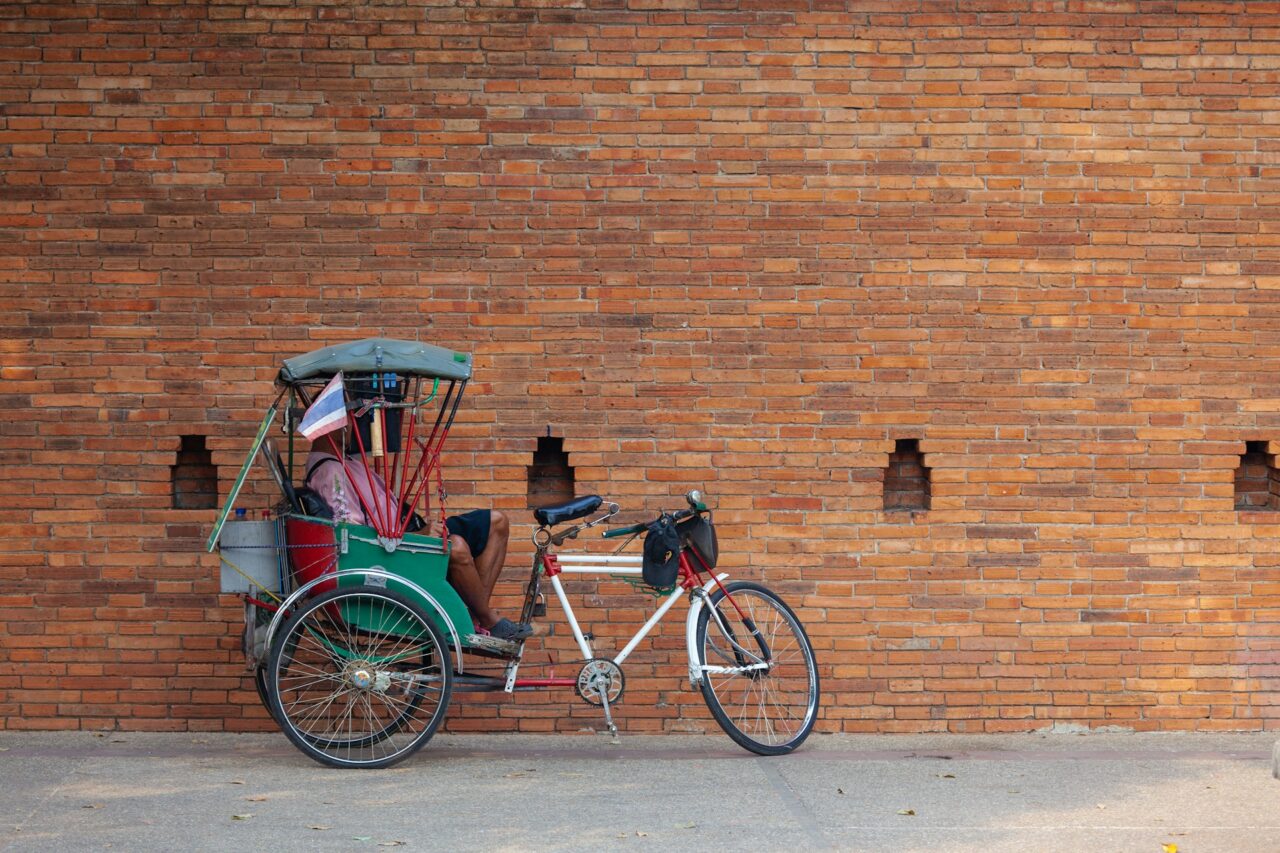 Rickshaw next to a brick wall