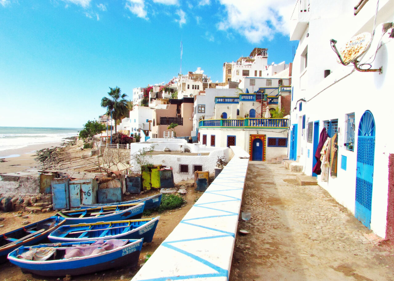 Whitewashed buildings and fishing boats on the beach in Taghazout, Morocco