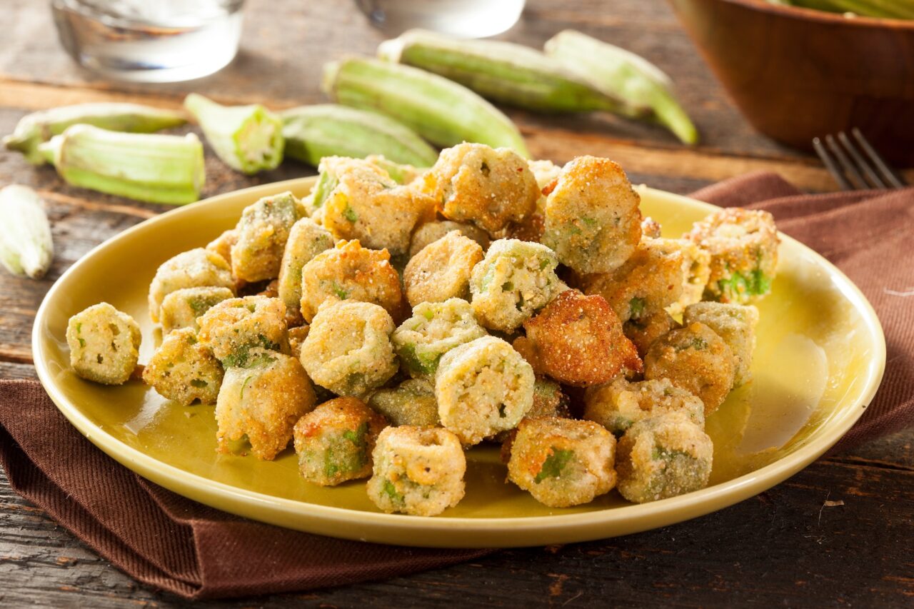 Plate of fried okra on a wooden table