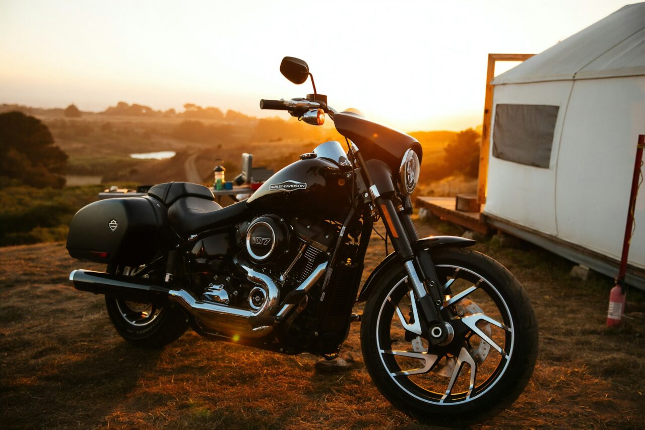 Harley Davidson motorbike parked on a hill at sunrise