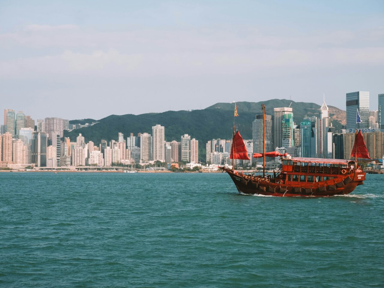 Red wooden junk boat sailing on the water in Hong Kong