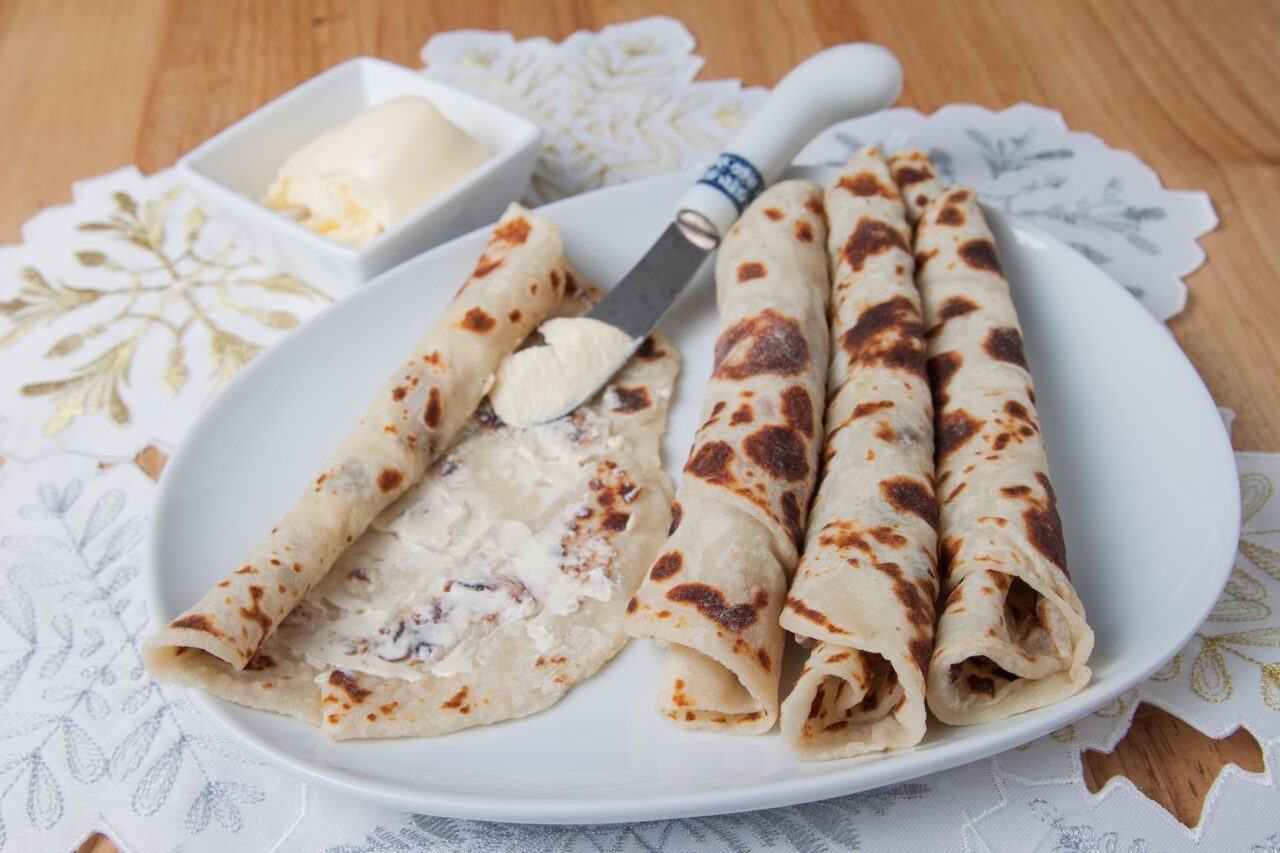 Lefse rolls on a white plate with butter - a Norwegian dish North Dakota is known for