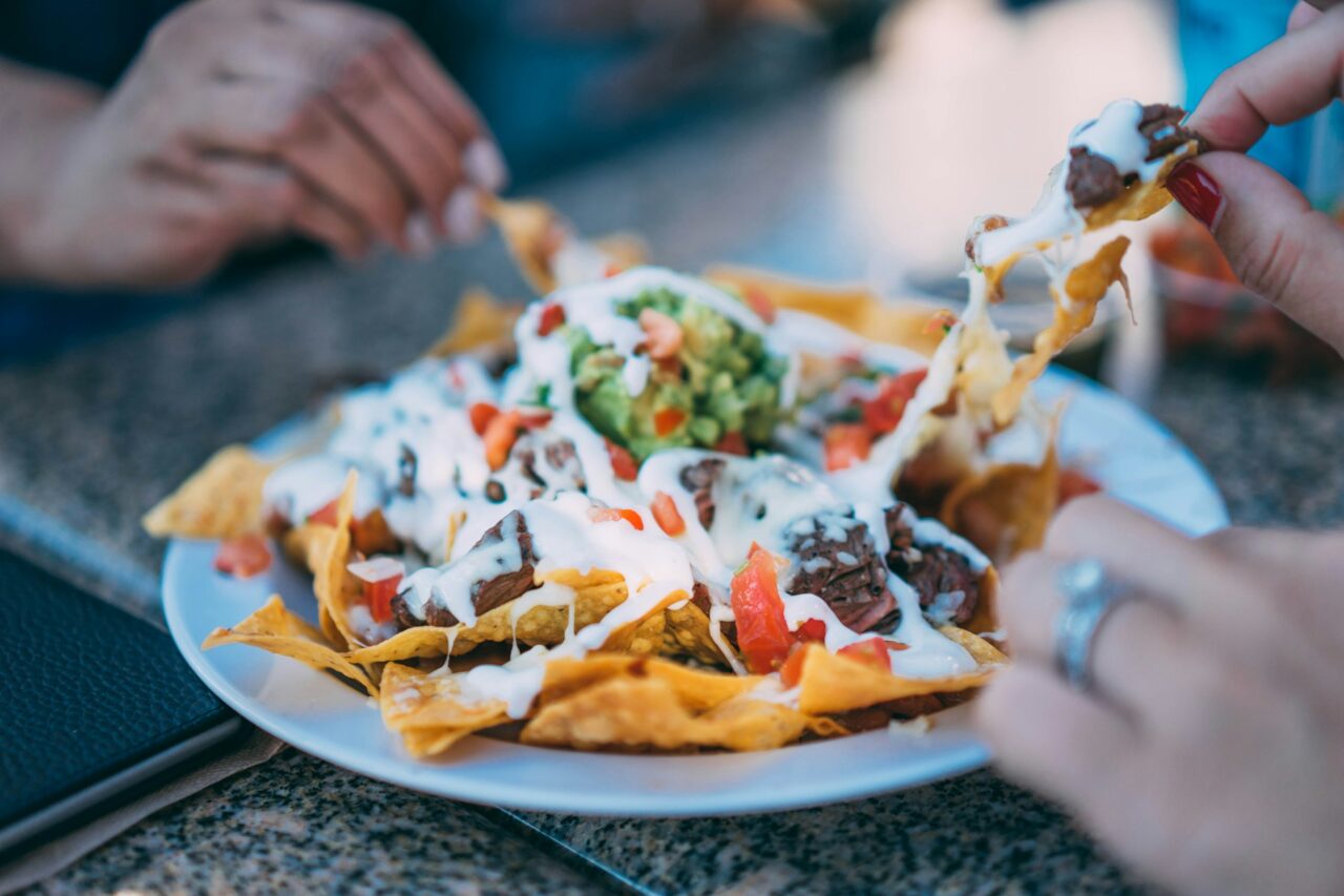 Close up of people eating nachos - typical Tex Mex food