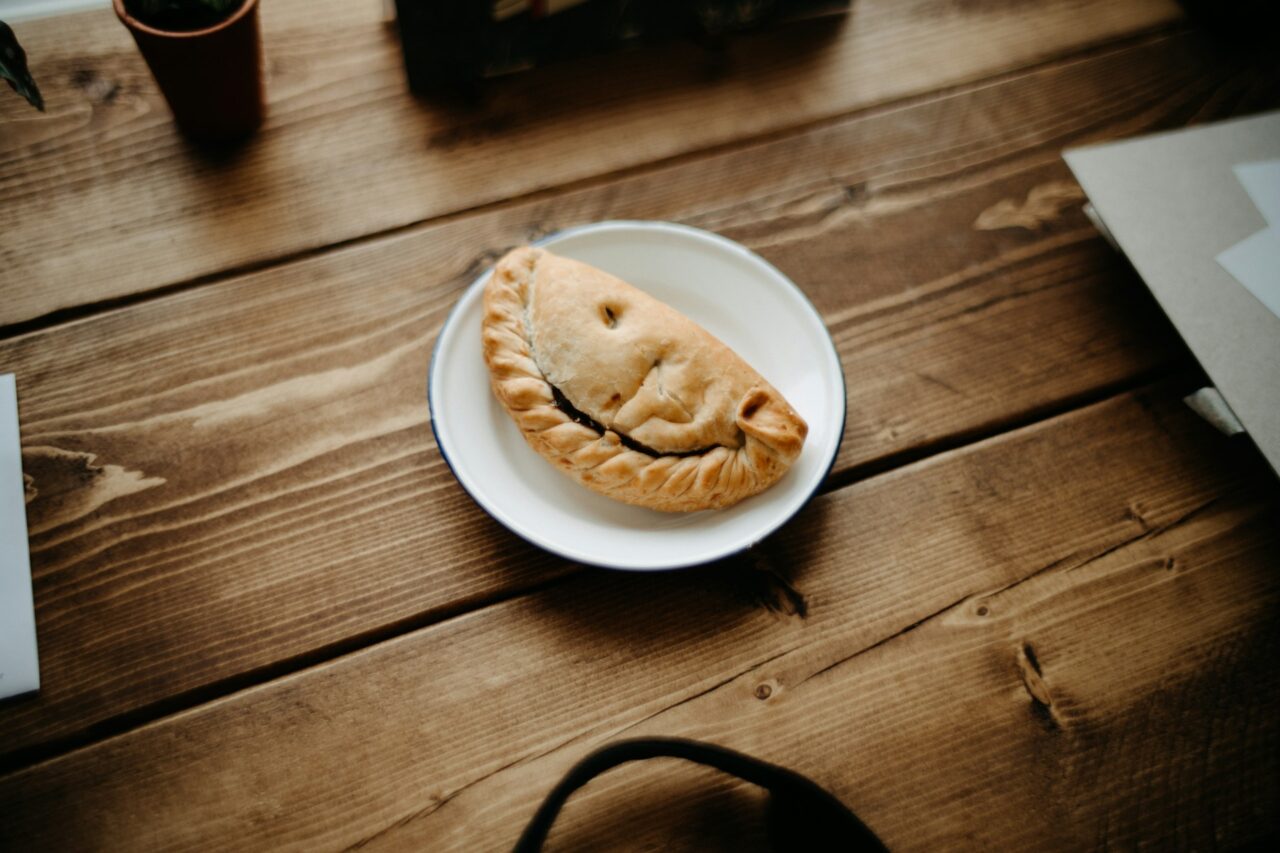 Pasty on a plate, sitting on a wood table