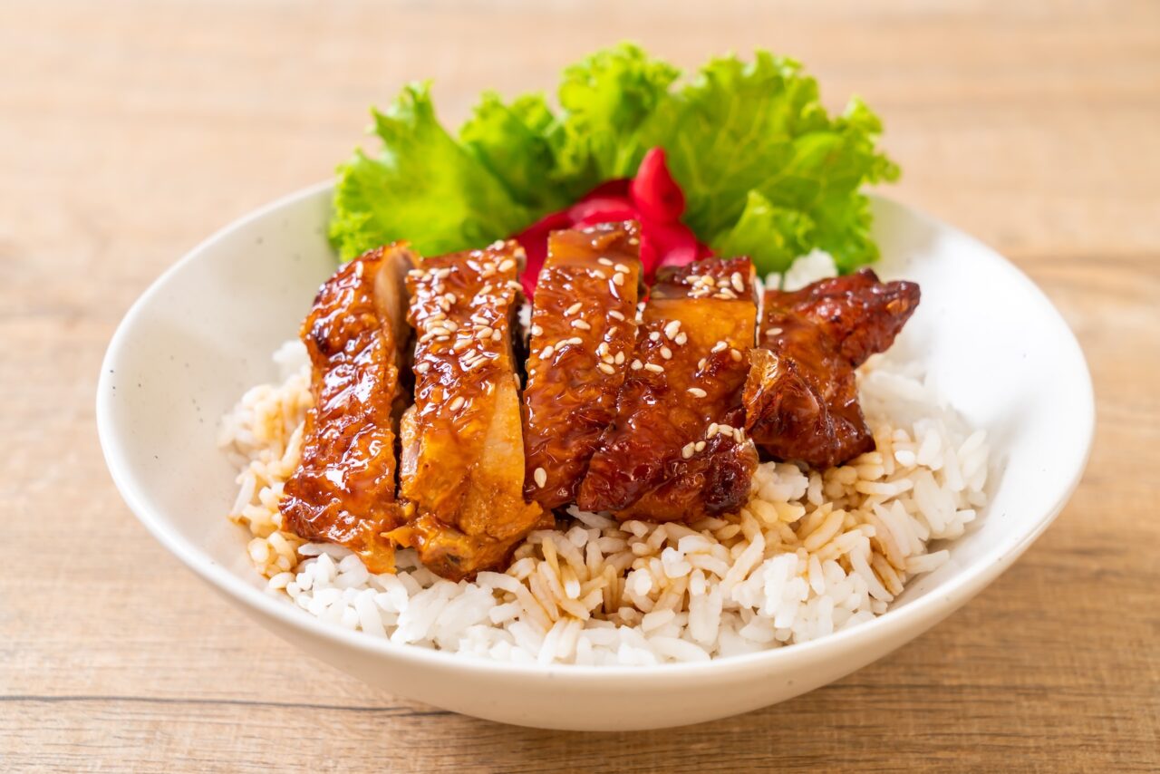 Teriyaki chicken on rice in a white bowl