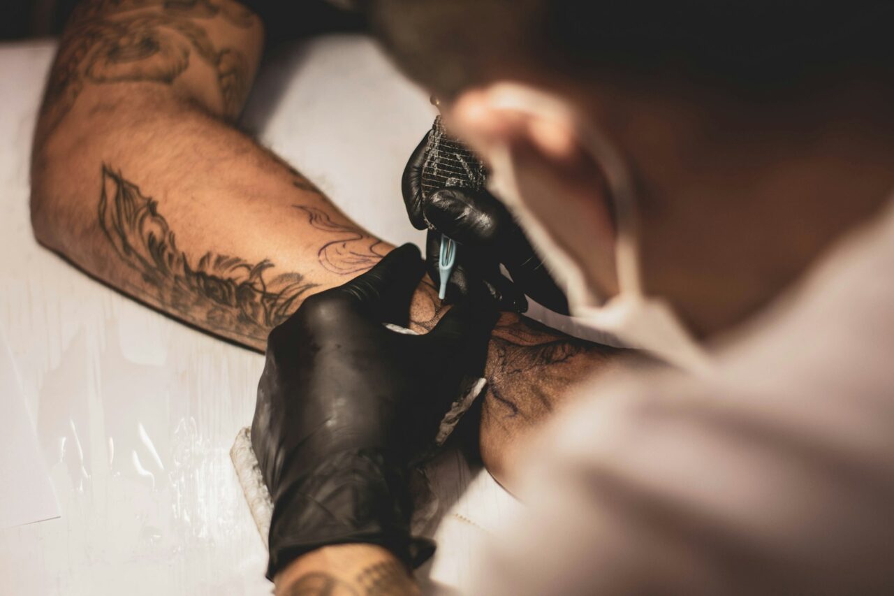 Person tattooing a man's arm