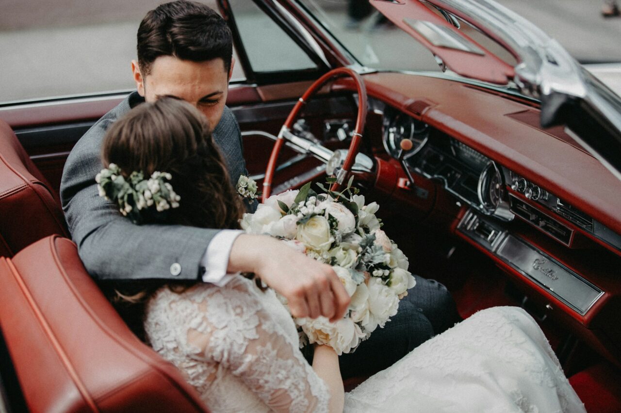 Bride and groom sitting in a vintage car