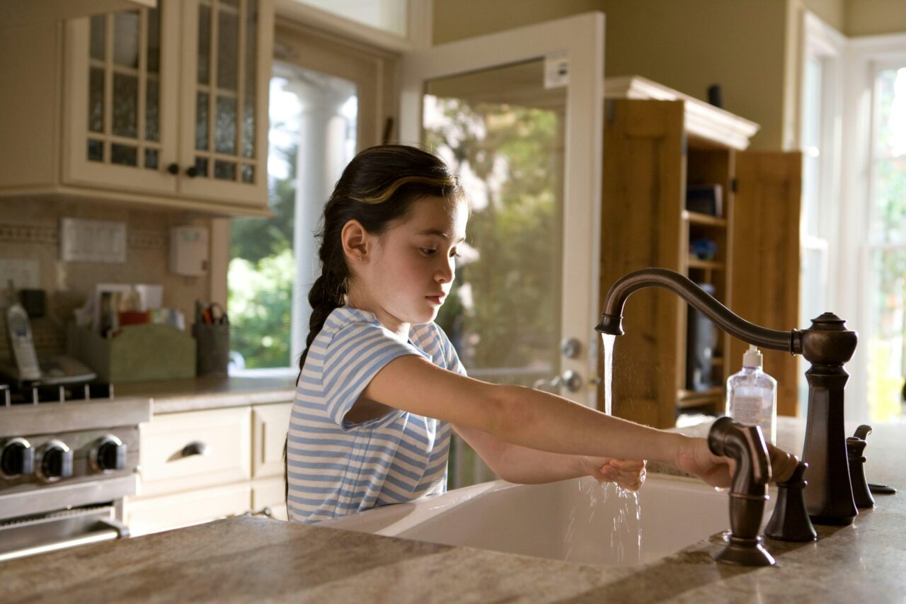 Girl washing hands in sink