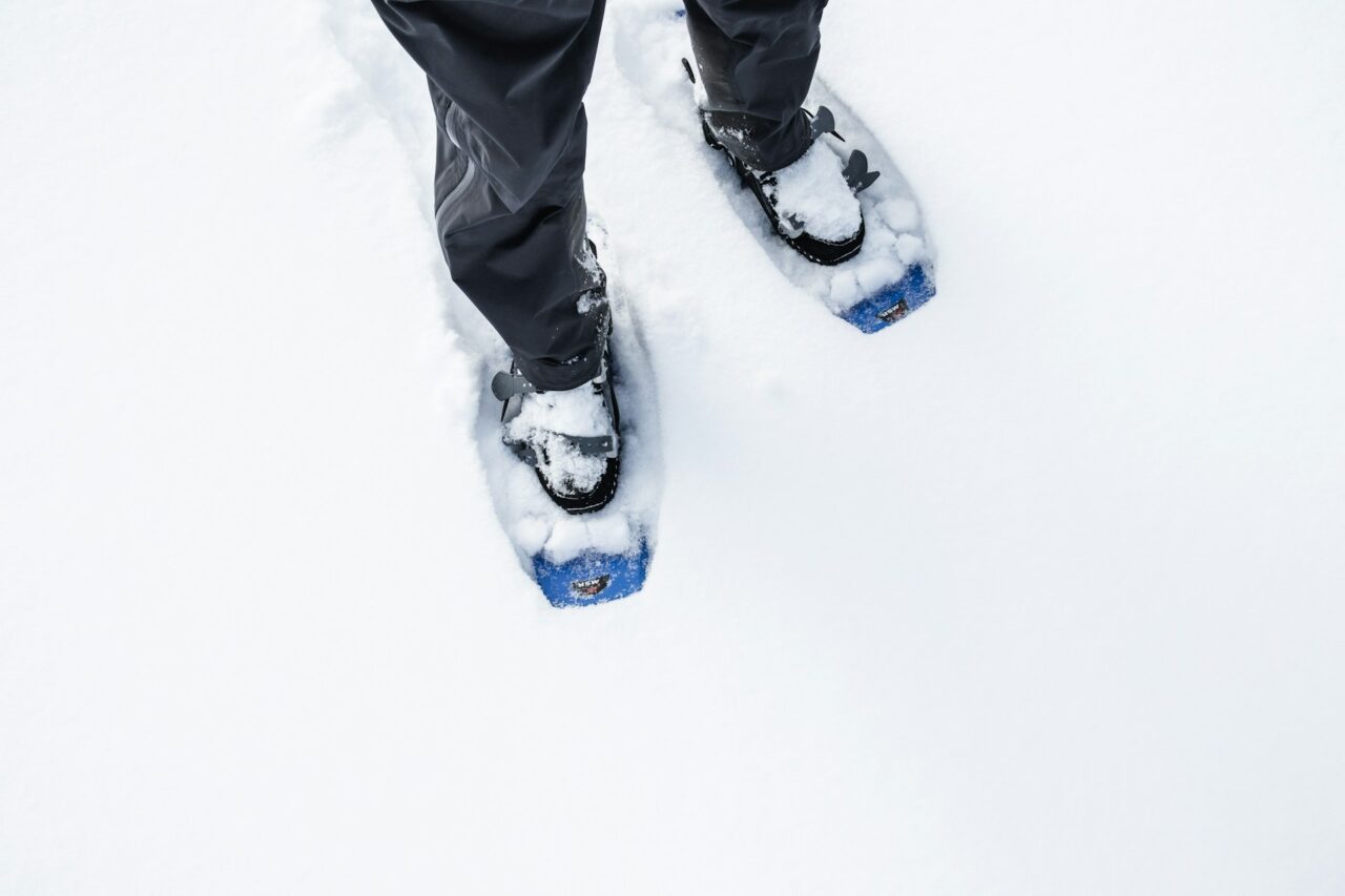 Close up of person's legs wearing snowshoes