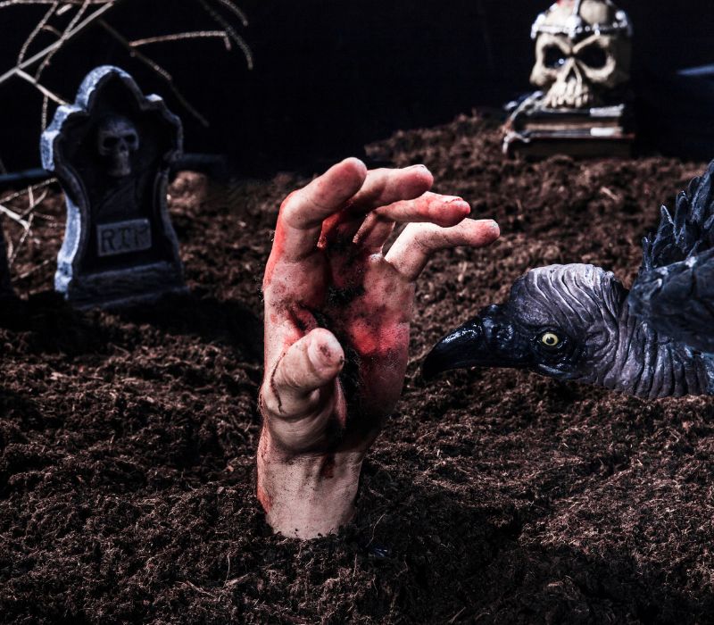 Spooky hand coming out of the ground in a graveyard