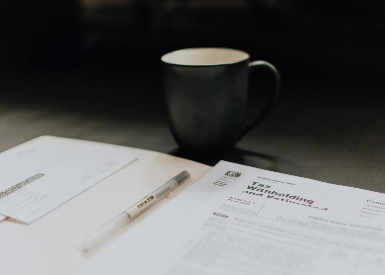 Tax documents on a table next to a coffee mug