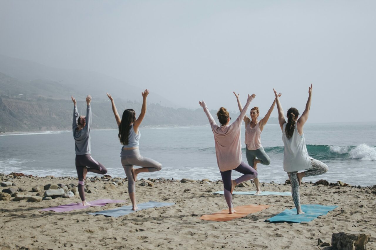 Group of women doing yoga on the beach