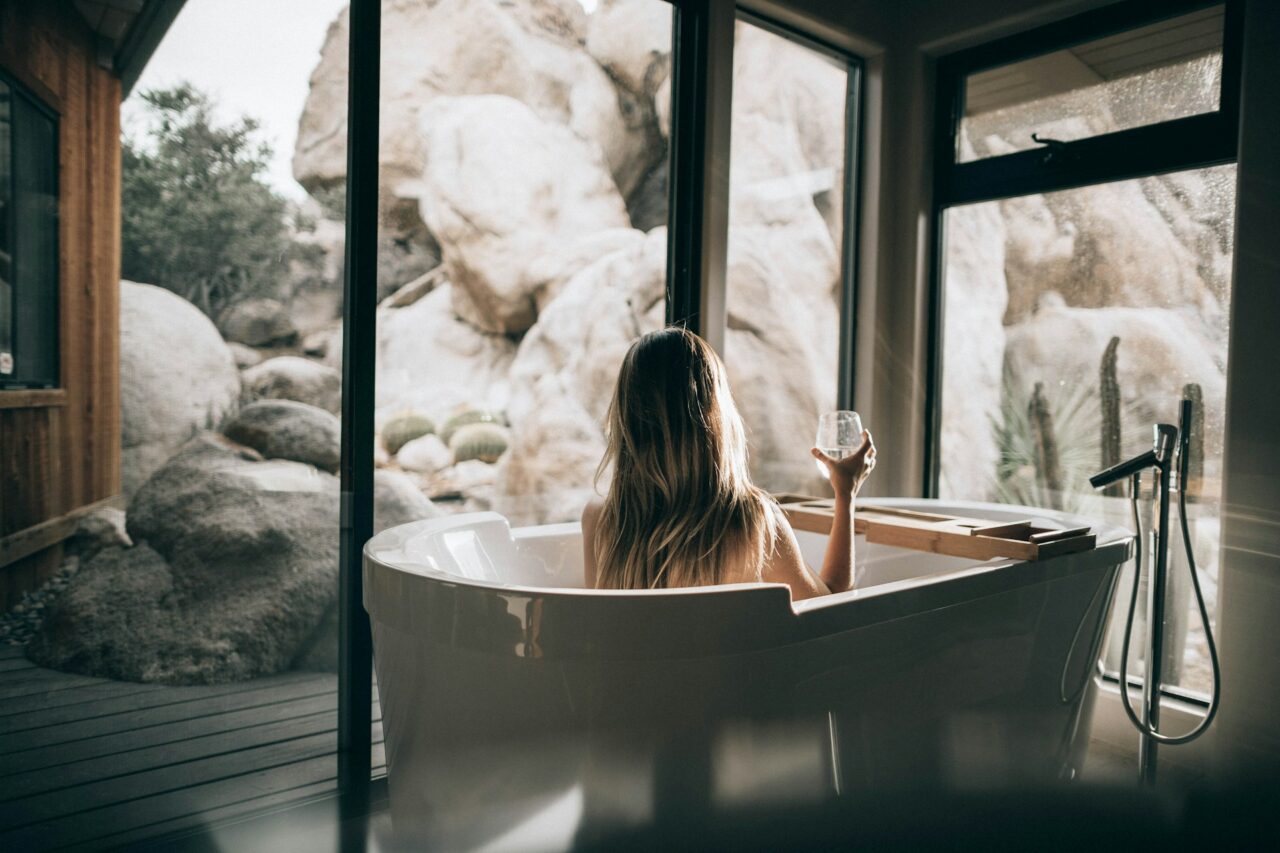 Woman in a bathtub holding a glass of wine