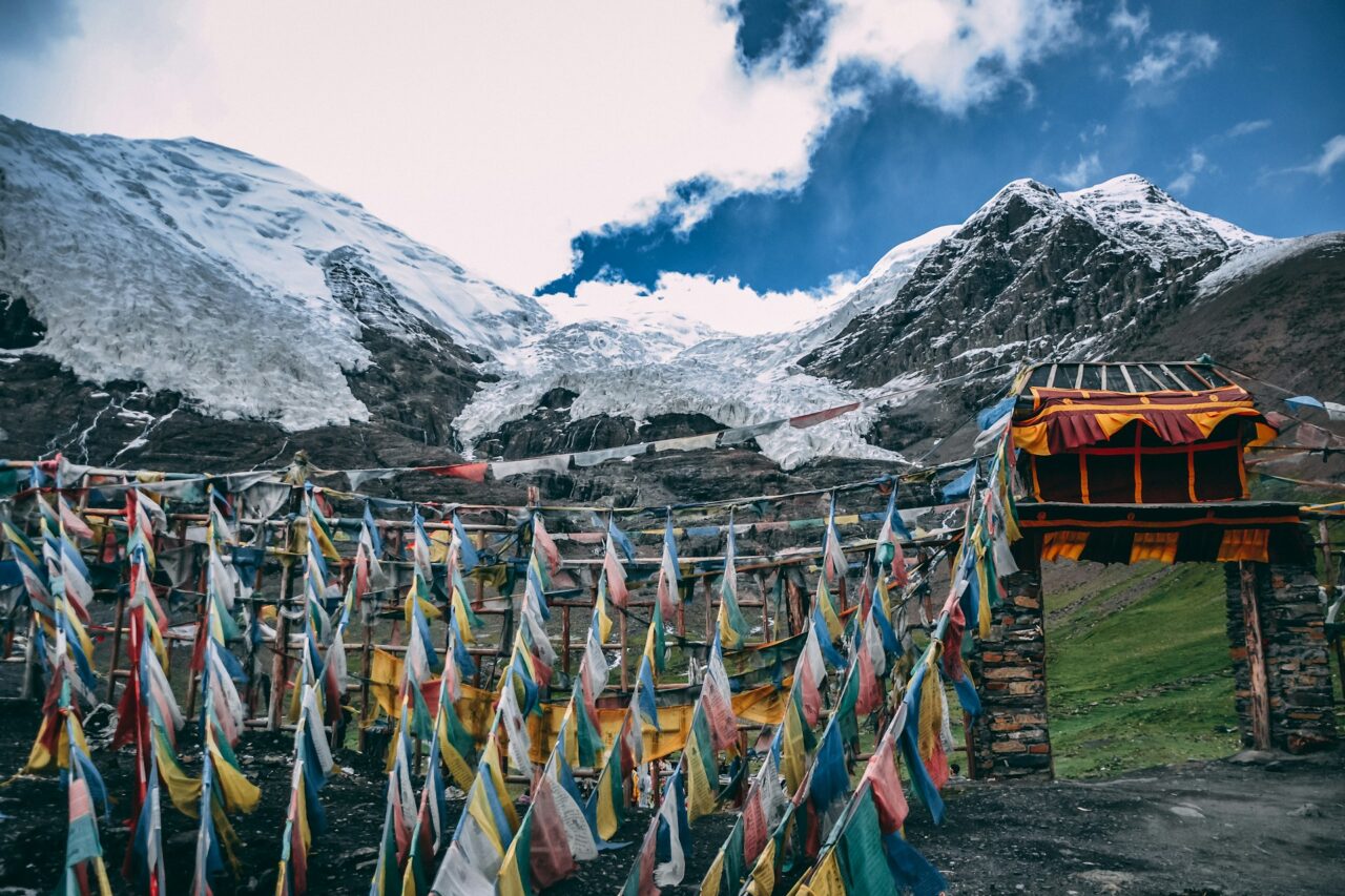 Flags next to a snowy mountain in Tibet