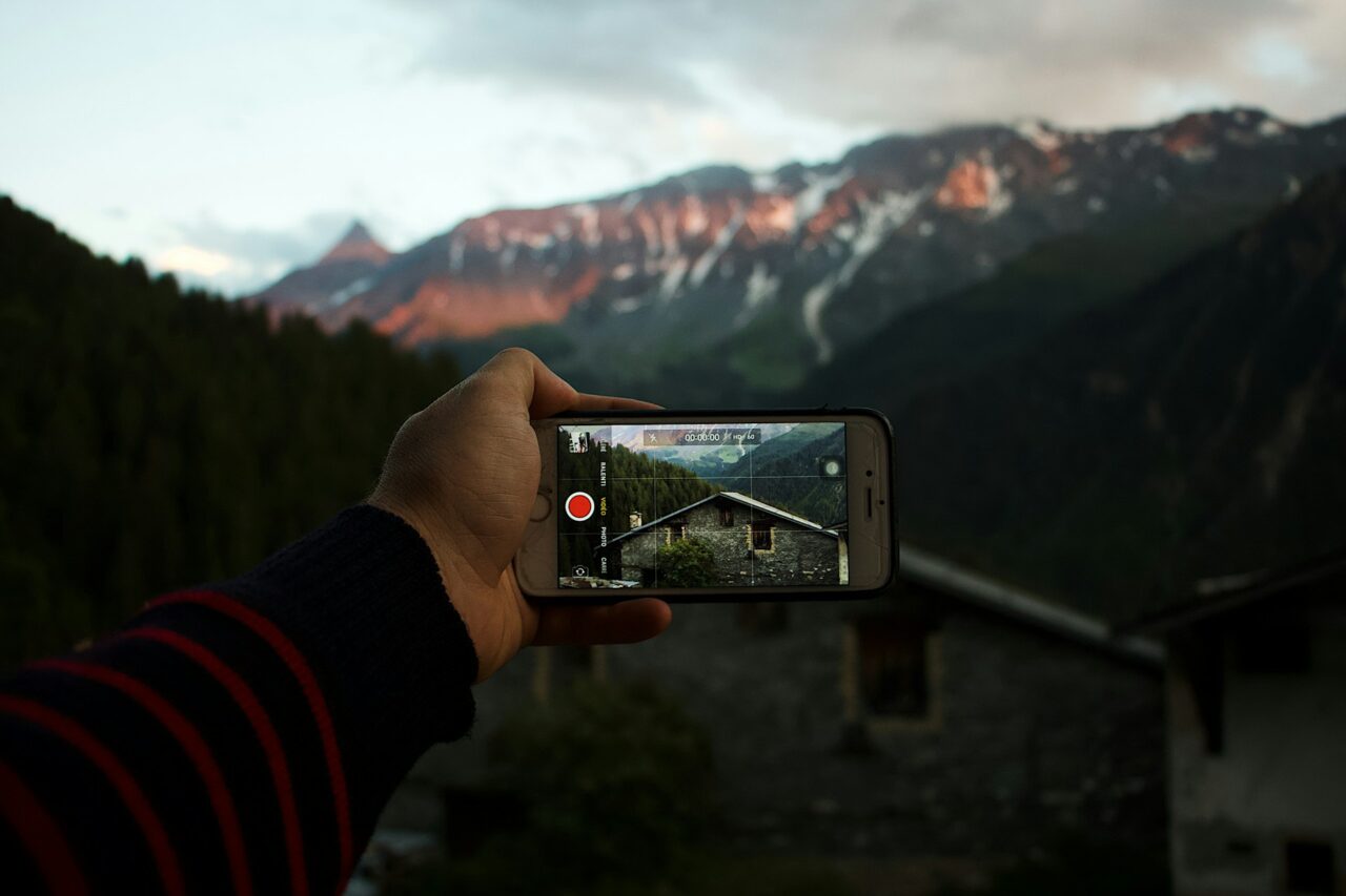Hand taking video of a mountain on an iphone