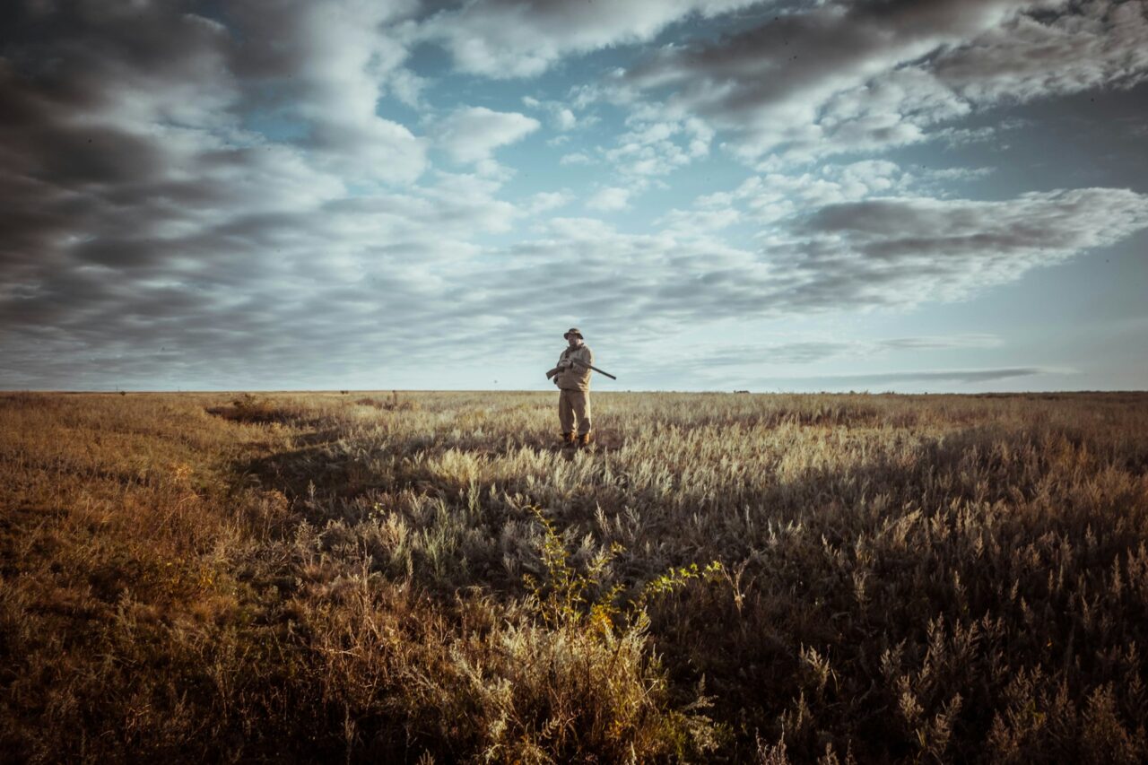 Man wearing hunting clothing standing in a field