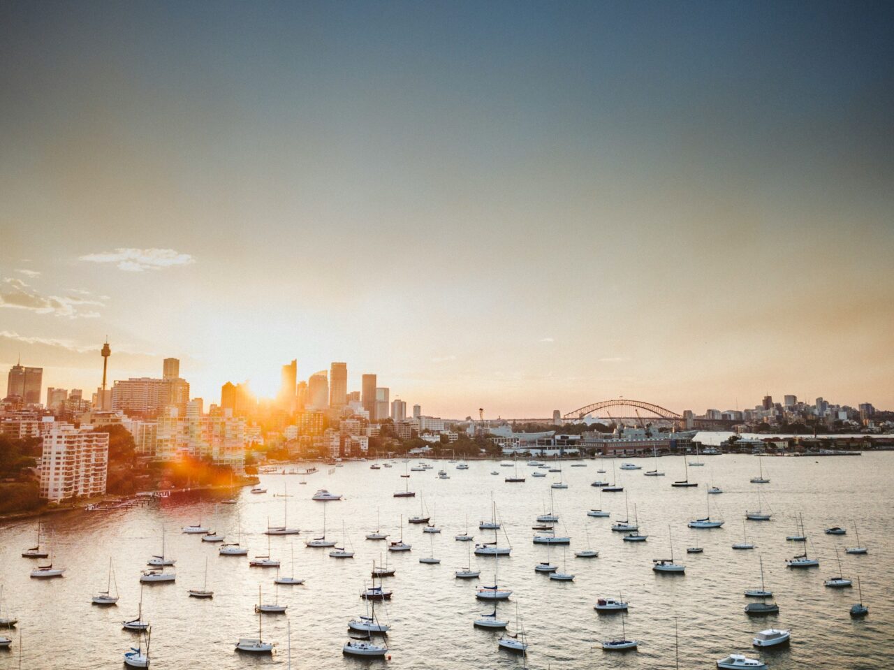 View of boats on the water with Sydney in the background at sunset