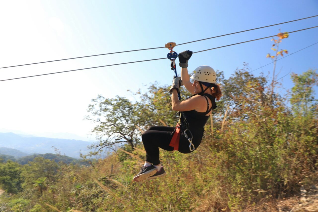 Woman zip lining over a forest