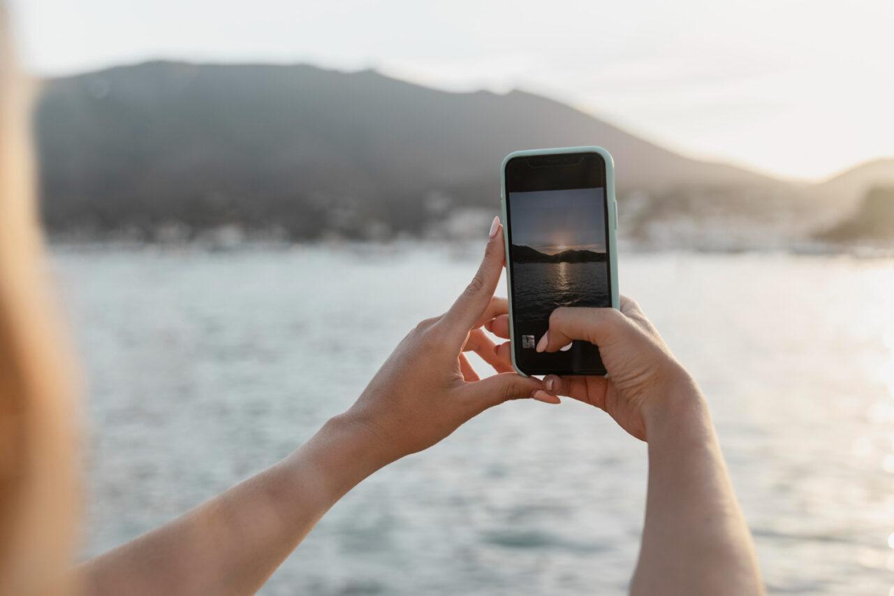 Person taking a photo of scenery with an iphone