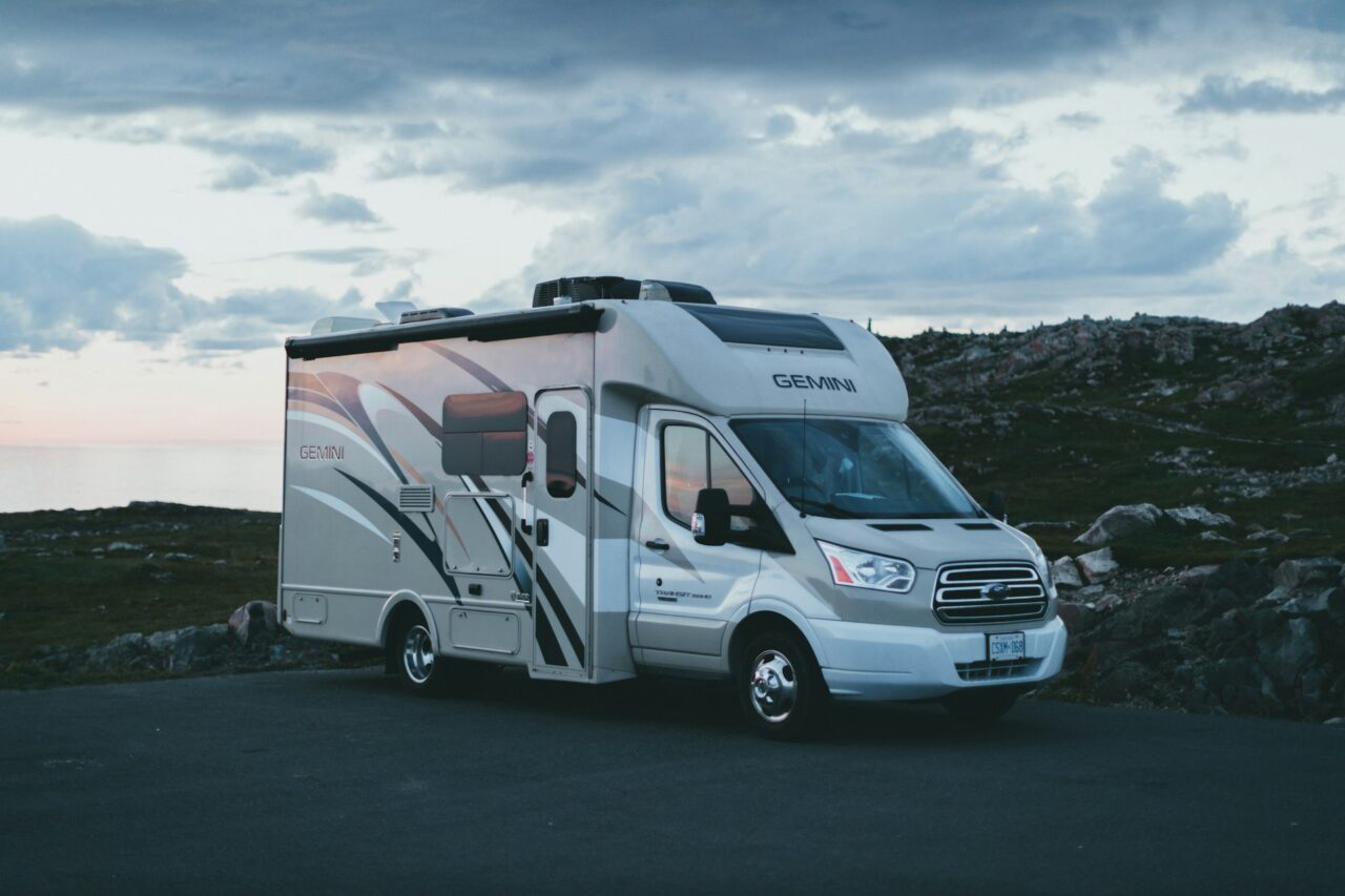 Versatile Gemini motorhome parked near rugged coastline at dusk, perfect for outdoor travel adventures.