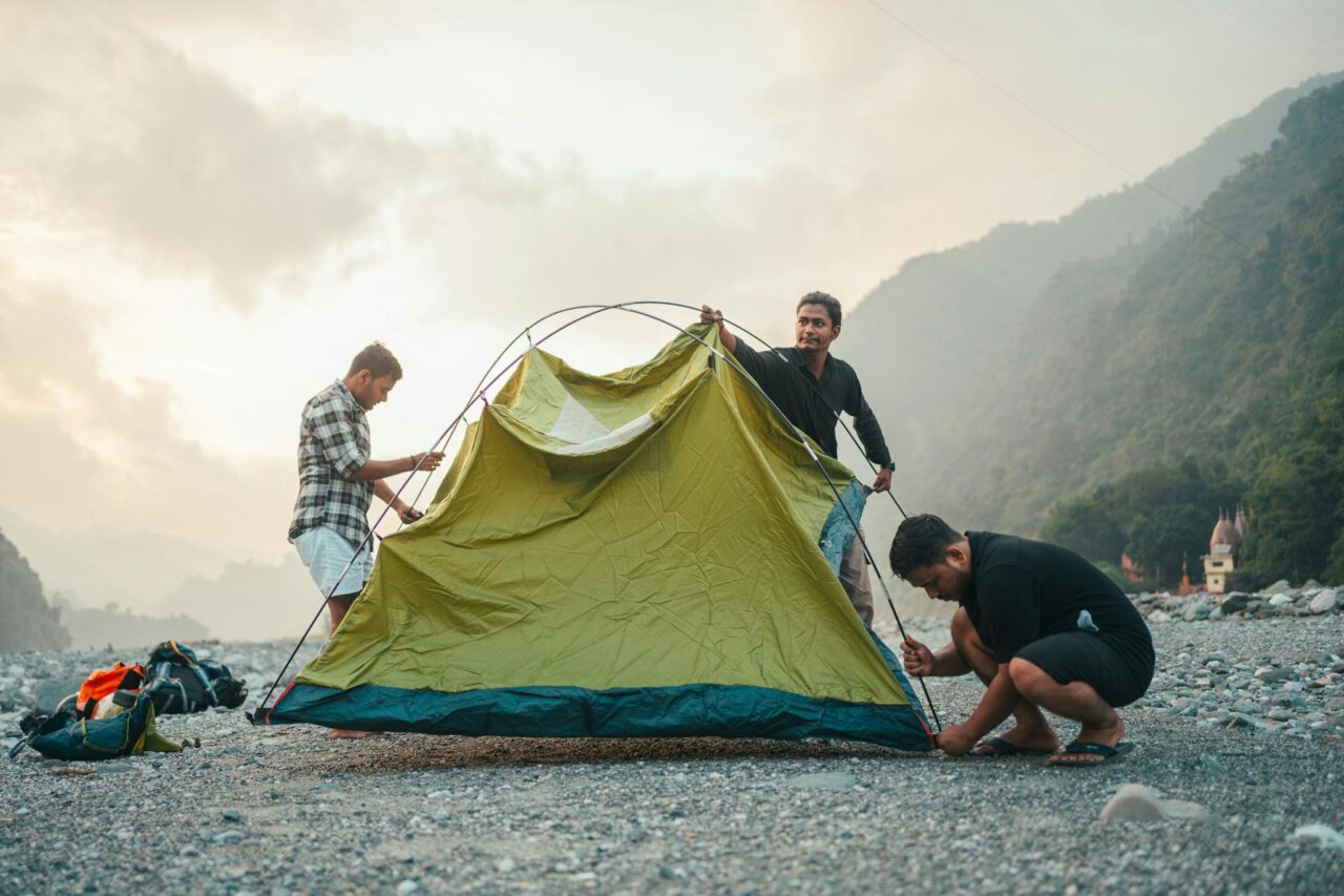 Group of people setting up a yellow camping tent