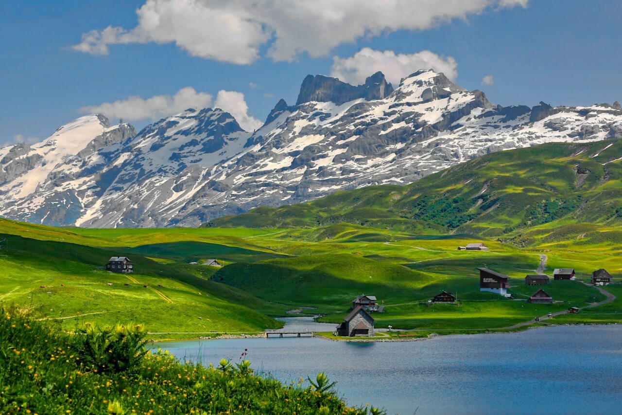 Lake with green hills and snow capped mountains