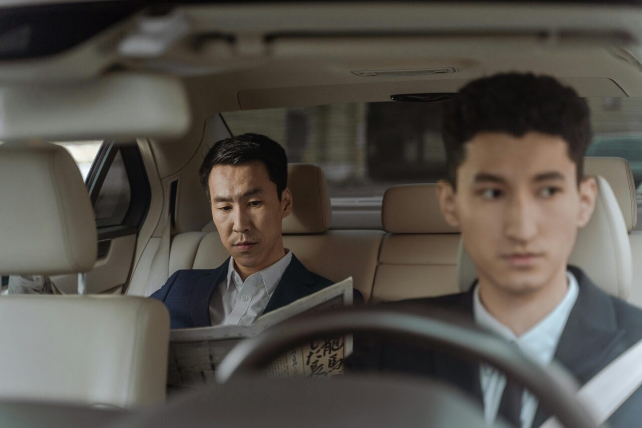 Chauffeur and businessman sitting in the back of a car