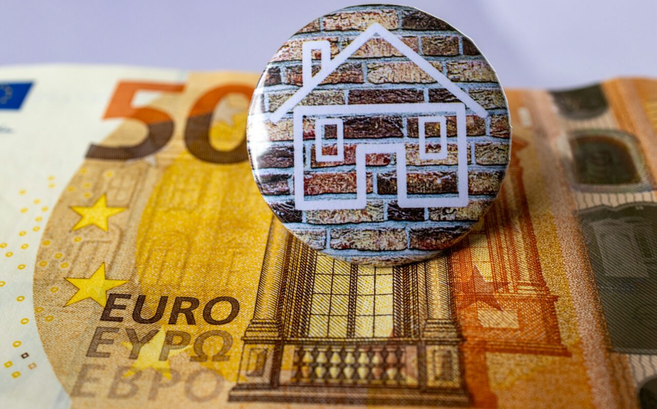 House badge sitting on top of 50 euro note