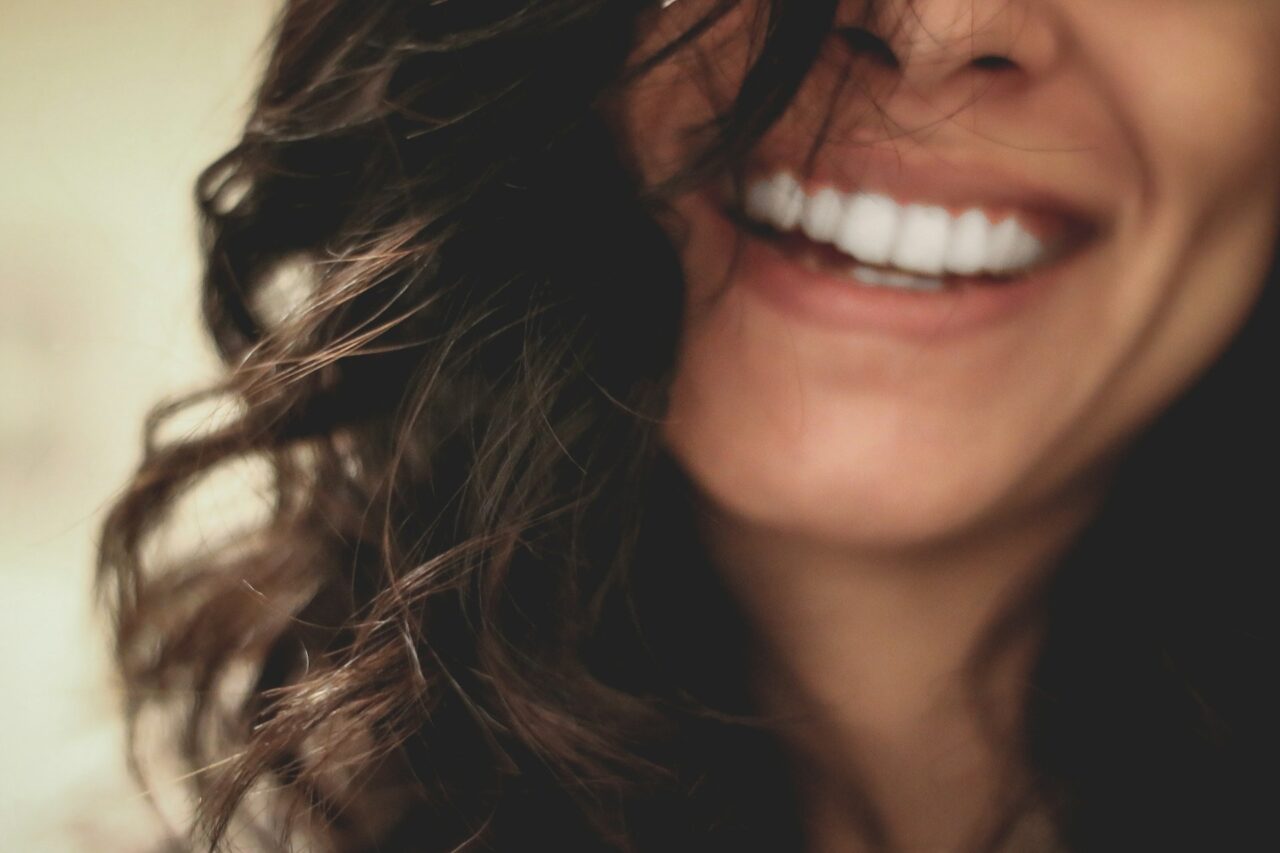 Woman with brown hair and white teeth