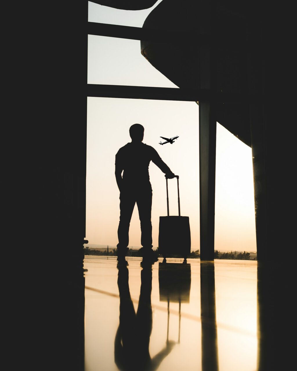 Silhouette of a traveler with a suitcase at an airport