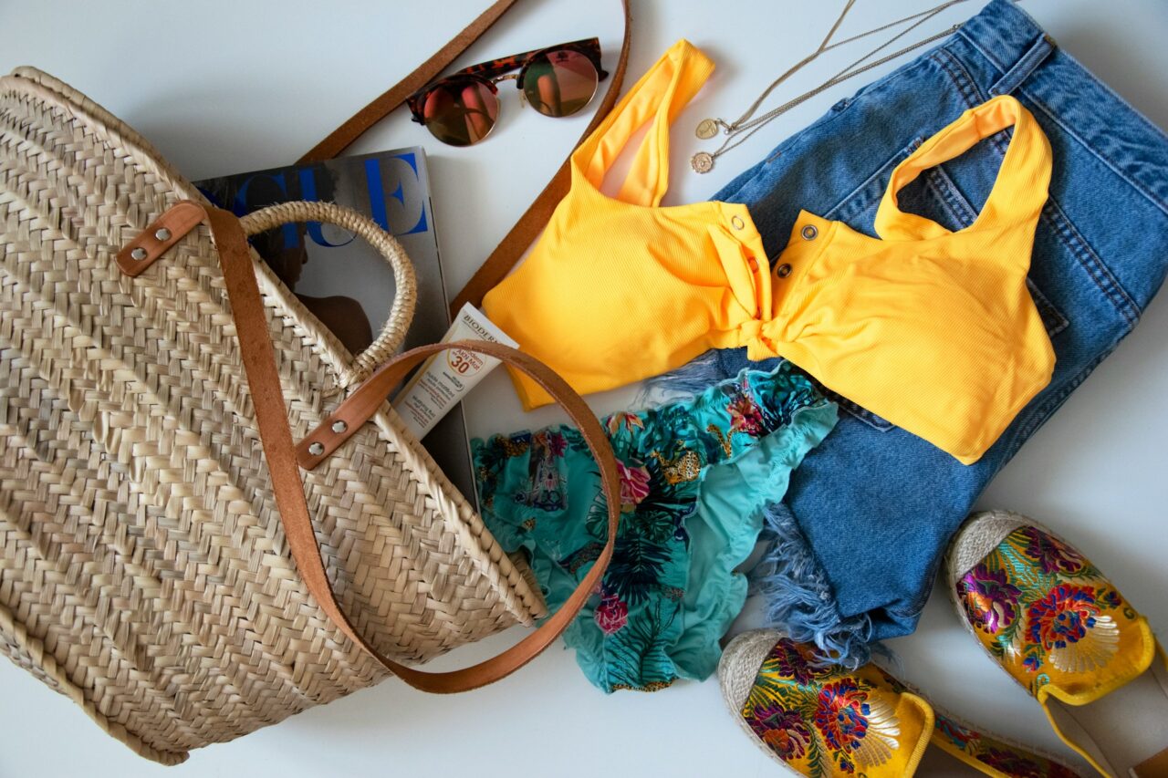 Beach bag flatly with bikini sunglasses and sandals