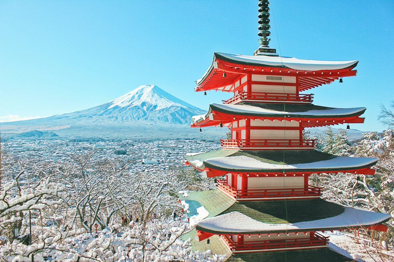 Red pagoda in front of a snowy mountain in Japan