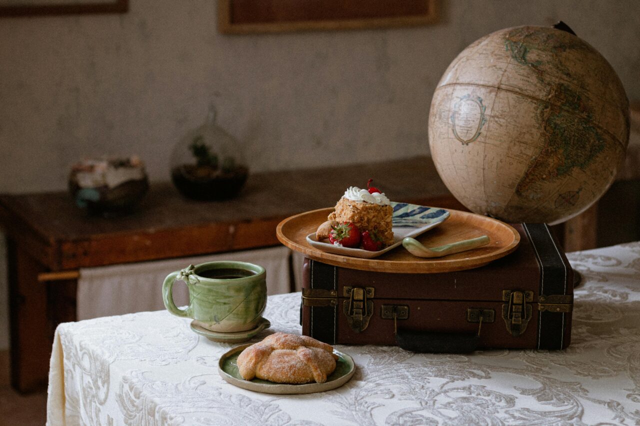 Vintage globe, coffee and cake on a table