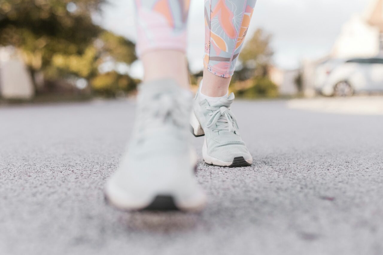 Close up of person's sneakers walking on a paved road
